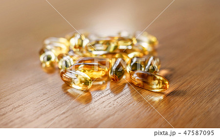 fish oil capsules on wooden table 47587095