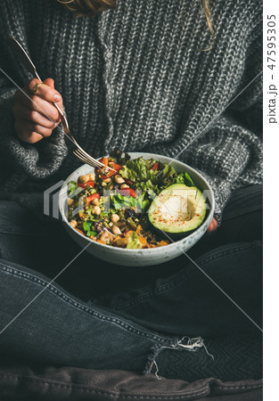 Woman eating fresh salad, avocado, beans and 47595305