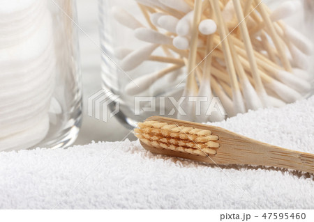 An organic biodegradable bamboo toothbrush with bamboo cotton swabs in the blurred background 47595460