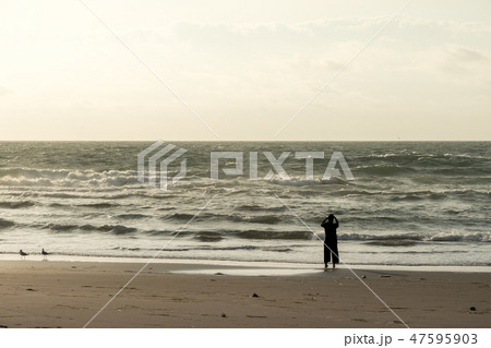 夕暮れ時の海岸を歩く女性 / 健康のイメージ 夕暮れ時の海岸を歩く女性 / 健康のイメージ 47595903