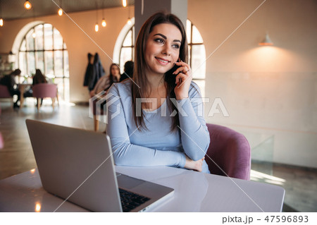 Business lady sitting in cafe and working on a laptop and using phone 47596893