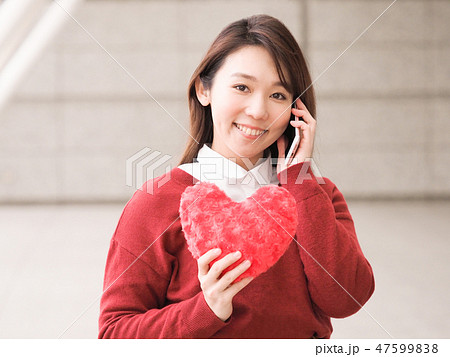 スマホと赤いハートを持つ女性 47599838