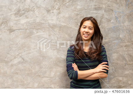 Pretty asian woman smiling in grey wall background 47601636