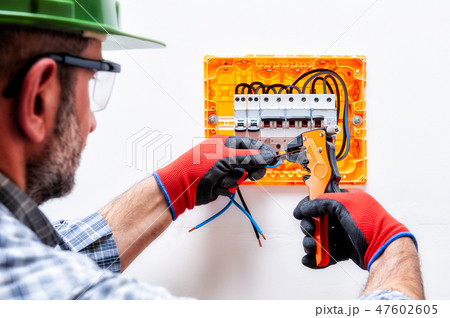 Electrician at work on an electrical panel. 47602605