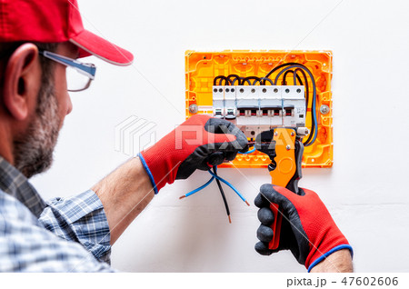 Electrician at work on an electrical panel. 47602606
