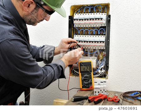 Electrician at work on an electrical panel 47603691