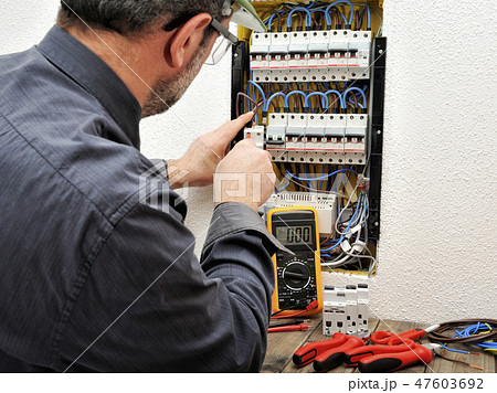 Electrician at work on an electrical panel 47603692