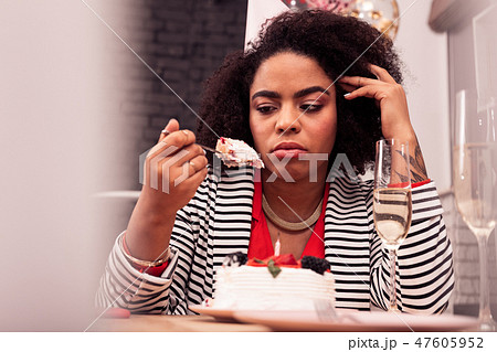 Cheerless upset woman celebrating her birthday alone Cheerless upset woman celebrating her birthday alone 47605952