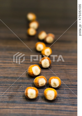 Whole hazelnuts on a wooden table.  47606486