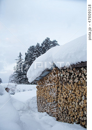 雪に埋もれた薪小屋 47609318