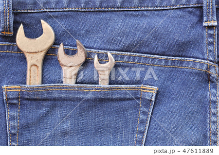 Blue jeans of back pocket and have old wrench tool with rust. Blue jeans of back pocket and have old wrench tool with rust. 47611889