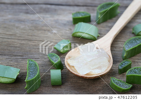 Sliced fresh Aloe Vera in wooden spoon on brown wood floor. 47612205