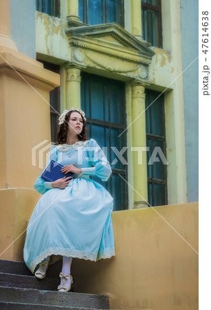 Young girl in a vintage dress reads a love story 47614638