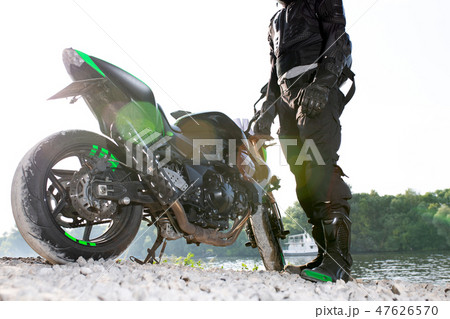 Biker man and motorcycle with river background, Rider moto trip on the street at the riverside Biker man and motorcycle with river background, Rider moto trip on the street at the riverside 47626570