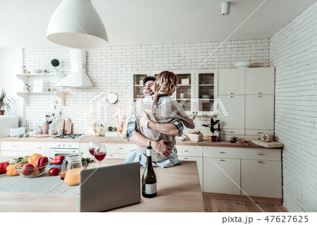 Handsome dark-haired smiling man in a checkered shirt and his beautiful wife feeling wonderful 47627625