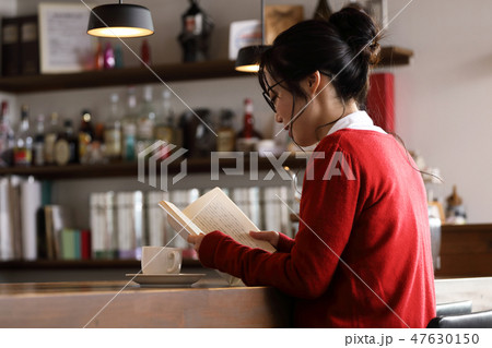 カフェで本を読む女性 47630150