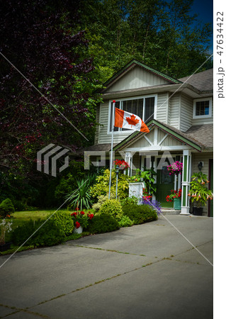 Main entrance of family house with canadian flag in front. Dark borders image Main entrance of family house with canadian flag in front. Dark borders image 47634422