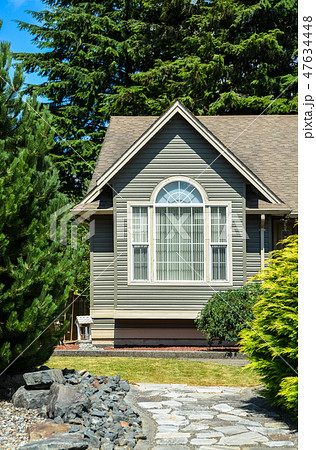 Living room window of residential house with paved pathway over front yard Living room window of residential house with paved pathway over front yard 47634448