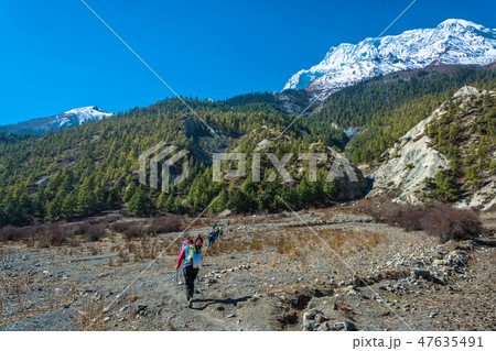 Group of tourists on a mountain path to the cave 47635491