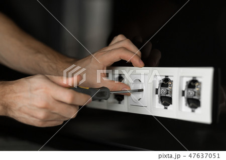 Close-up of an electrician's hand with screwdriver Close-up of an electrician's hand with screwdriver 47637051