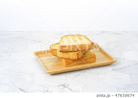 Slices toast bread in wooden dish on table. 47638674