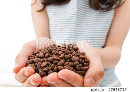 コーヒー豆を持つ若い女性 47638756