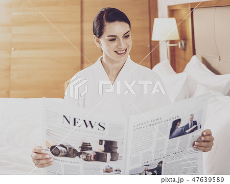 Attractive businesswoman reading the newspaper 47639589