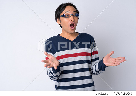 Portrait of Japanese man looking shocked with arms raised Portrait of Japanese man looking shocked with arms raised 47642059