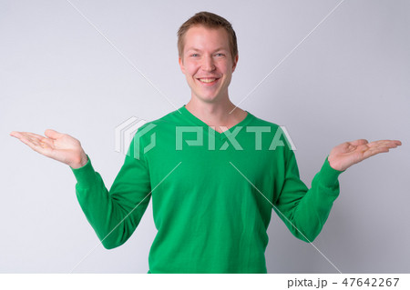 Portrait of happy young handsome man comparing something 47642267
