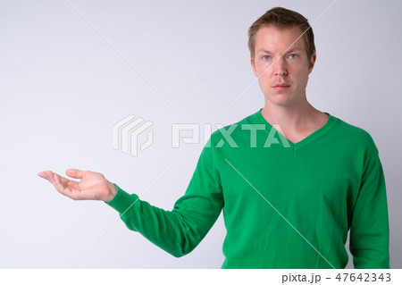 Portrait of young handsome man showing something Portrait of young handsome man showing something 47642343