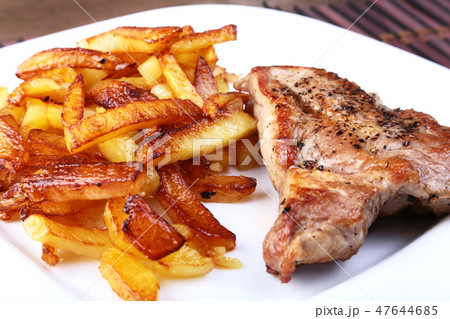 Grilled free-range beef steak with potato free, fresh tomatoes and sauce on a brown stone background Grilled free-range beef steak with potato free, fresh tomatoes and sauce on a brown stone background 47644685