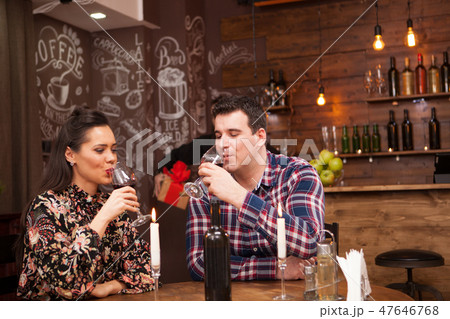 Happy husband giving wife a present in a hipster pub. Happy husband giving wife a present in a hipster pub. 47646768