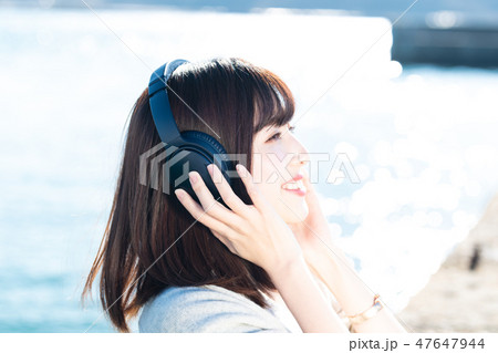 音楽を聴く若い女性 47647944