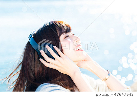 音楽を聴く若い女性 47647945