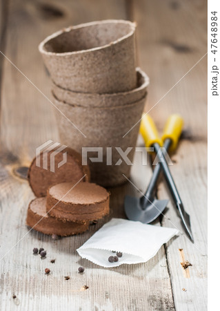 Garden tools, peat pots and seeds on wooden table Garden tools, peat pots and seeds on wooden table 47648984
