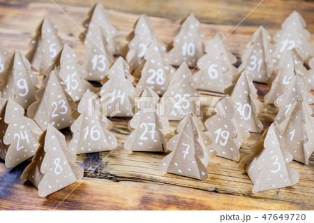 Handmade Christmas advent calendar Christmas trees Kraft paper with numbers in wood background. 47649720