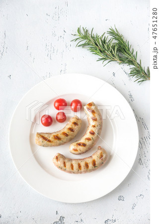 Grilled sausages with cherry tomatoes 47651280