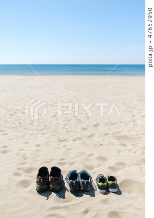 Three pairs of sneakers are on the sand. The concept of the weekend 47652950