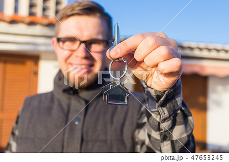 Ownership, real estate, property and tenant concept - Portrait of a cheerful young man holding key 47653245