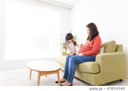妊娠した女性とお腹に耳をあてる子ども 47654540
