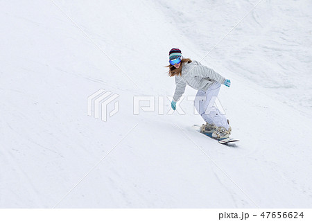 Female snowboarder rocking the slopes in winter Female snowboarder rocking the slopes in winter 47656624