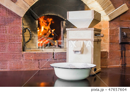 Small wooden windmill stands on the table next to the Russian stove Small wooden windmill stands on the table next to the Russian stove 47657604
