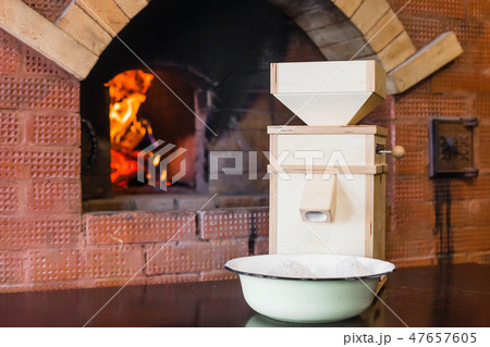 Small wooden windmill stands on the table next to the Russian stove Small wooden windmill stands on the table next to the Russian stove 47657605