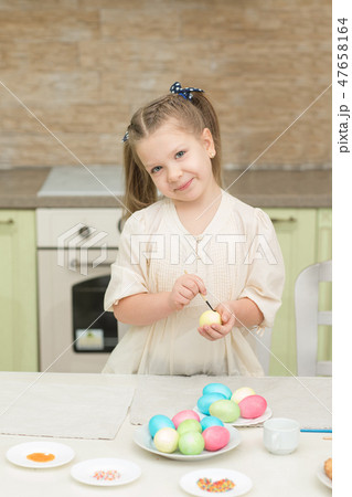 little girl having fun to paint easter eggs 47658164