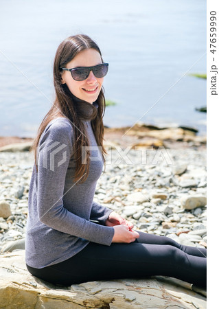 woman Enjoying Beautiful Sunset at the Beach 47659990
