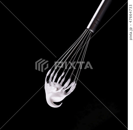 Metal whisk with whipped egg whites, isolated on black background. Clipping path. 47664733