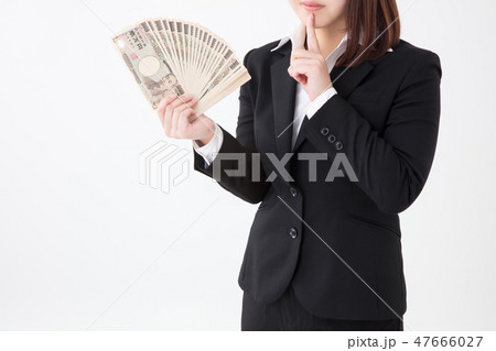 スーツの女性が何十万のお金を持ち内緒のポーズをしている スーツの女性が何十万のお金を持ち内緒のポーズをしている 47666027