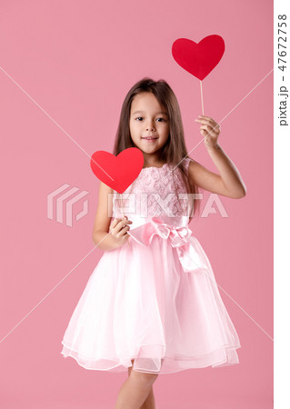 cute little girl in a pink dress holding a paper heart cute little girl in a pink dress holding a paper heart 47672758