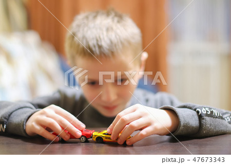 Happy child 6-8 years play with his car toy Happy child 6-8 years play with his car toy 47673343