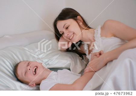 Mom and son playing with each other lying in bed in the morning. Mom and son playing with each other lying in bed in the morning. 47673962
